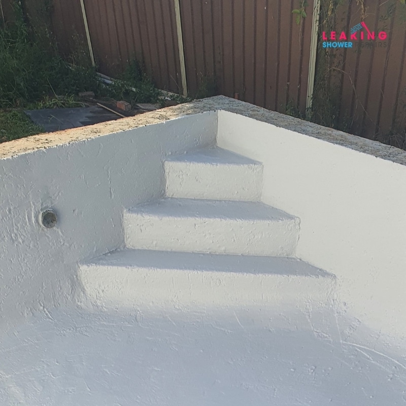 Waterproofing application on concrete pool steps, showcasing a newly coated, smooth surface designed for enhanced water resistance.