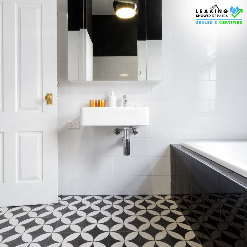 Trusted tiling company for quality work: Elegant black and white tiled bathroom with a patterned floor.