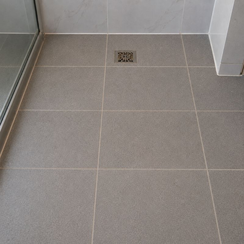 The same ensuite shower floor after repair, with joints refilled evenly in a flexible grout.
