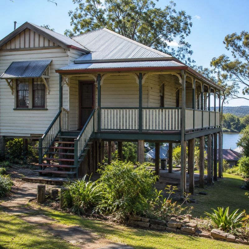 Older Hawkesbury home built up on piers above ground level with the yard sloping away below.